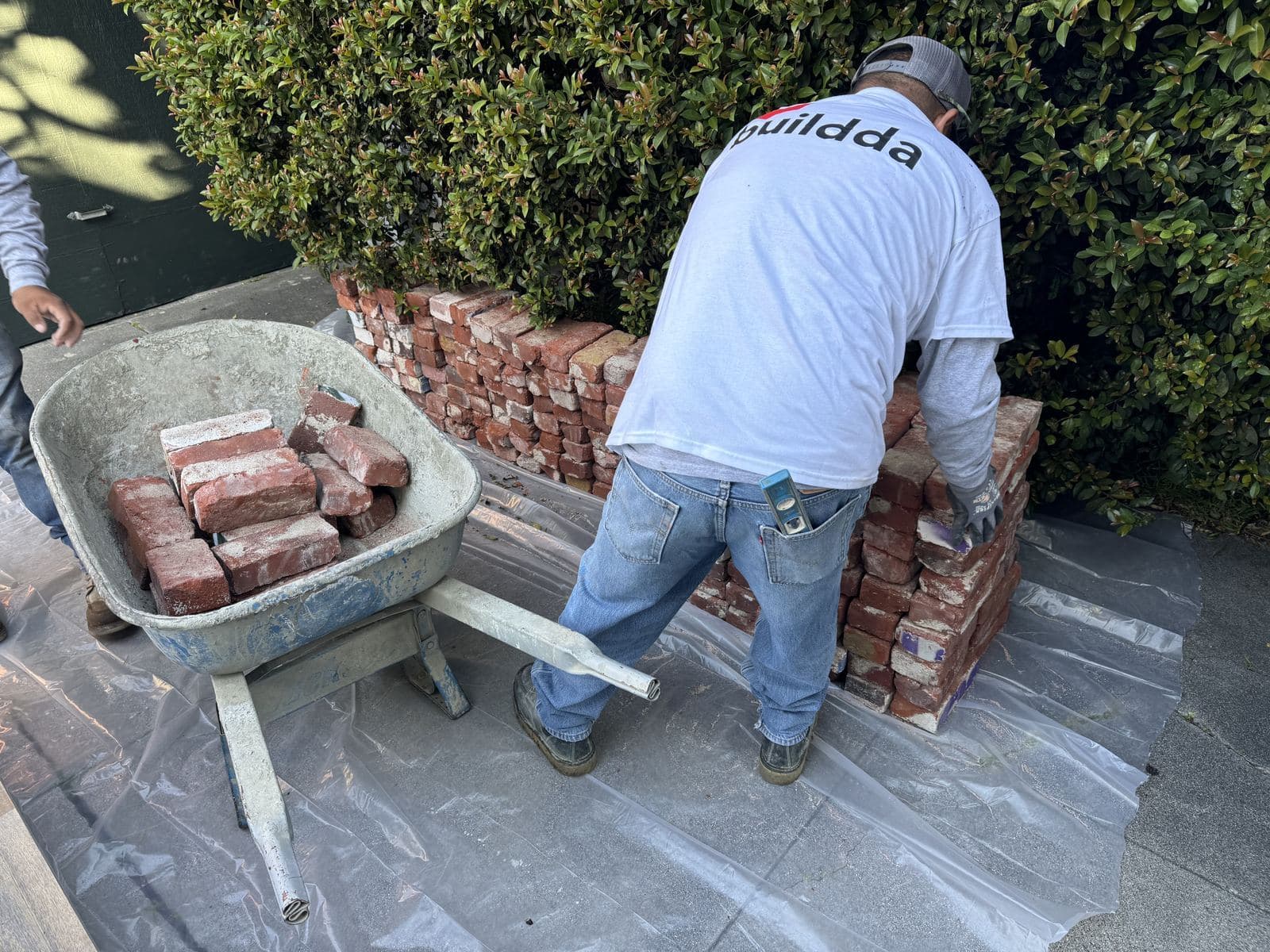 Buildda crew member wheeling reclaimed bricks to a walkway job in Culver City
