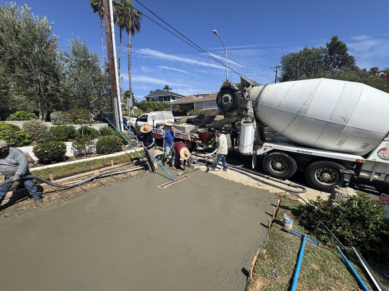 Concrete mixer truck and crew placing concrete for the new driveway in Culver City