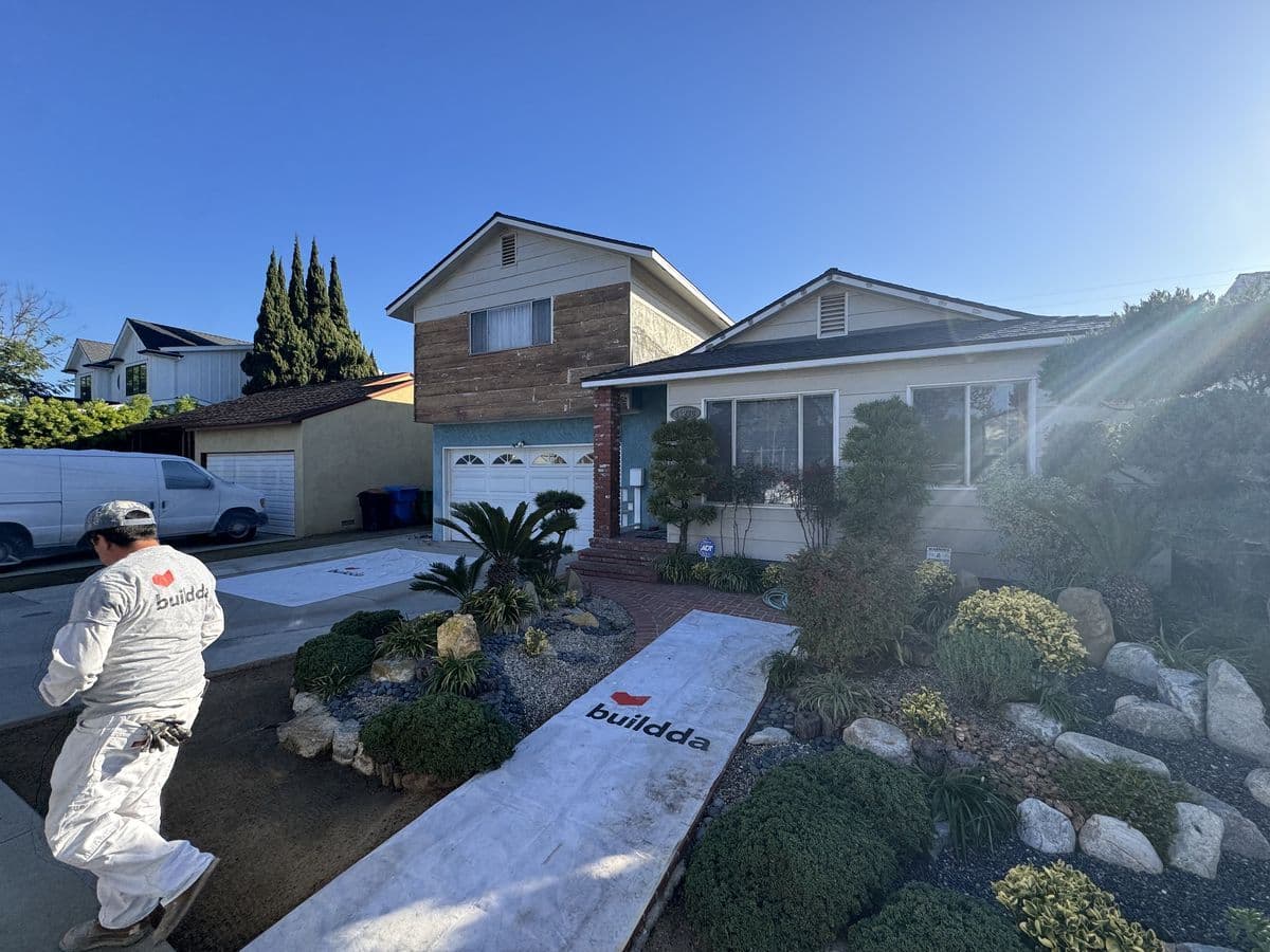 Exterior painting prep with drop cloths protecting Culver City home landscape